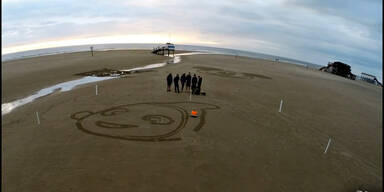 Robotor malt Bilder in den Sand