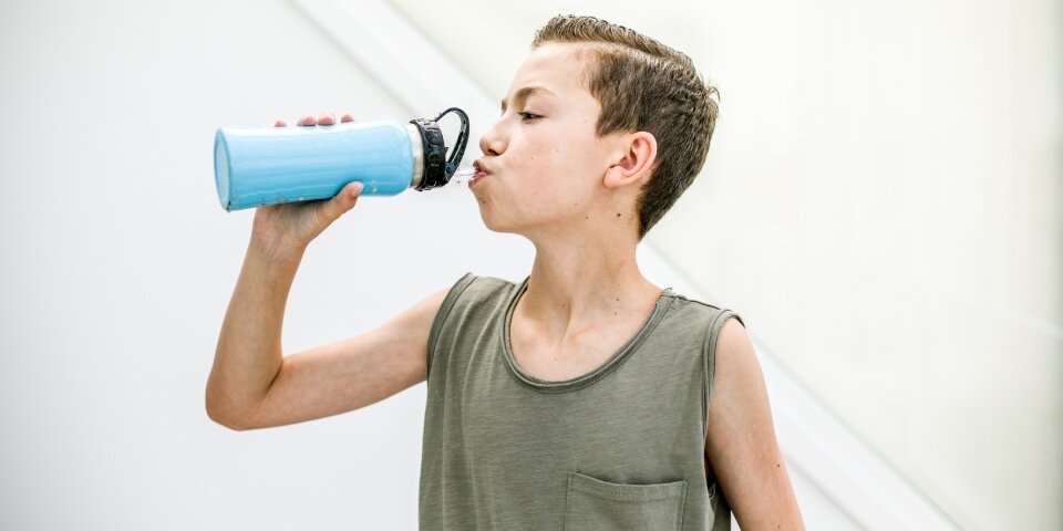 Kind trinkt aus Frinkflasche