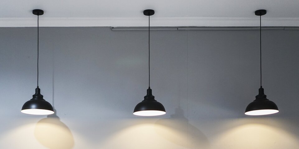 3 schwarze Lampen die von der Decke hängen