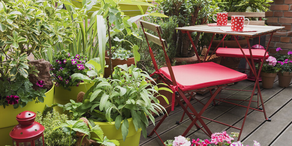 Viele Pflanzen und Sitzmöglichkeiten am Balkon