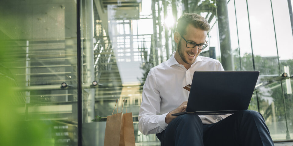 Mann mit Laptop und Kreditkarte