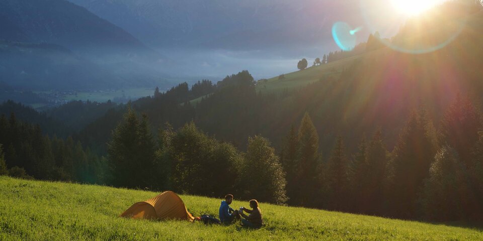 Paar zeltet am sonnigen Hügel