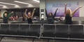 Irre Frauen tanzen am Flughafen