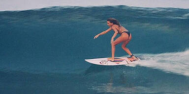 Surfer-Girl reitet nackt auf der Welle