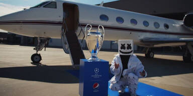 Star-Dj Marshmello kniet neben dem Champions-League-Pokal