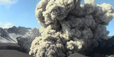 Vulkan spuckt Rauch und Asche